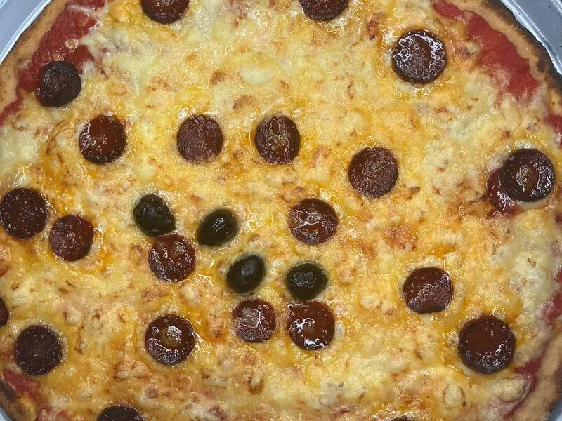 Pizza chorizo pepperoni cuite au feu de bois